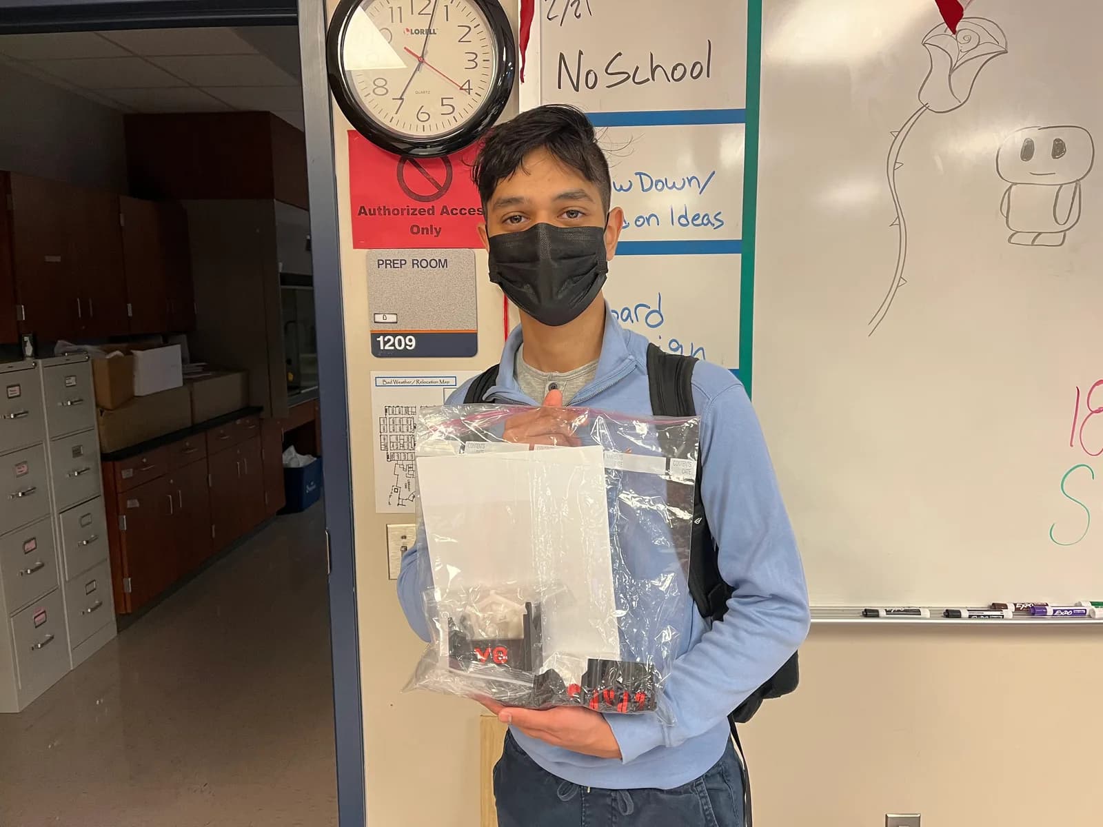 Member holding a sealed competition kit bag in the classroom