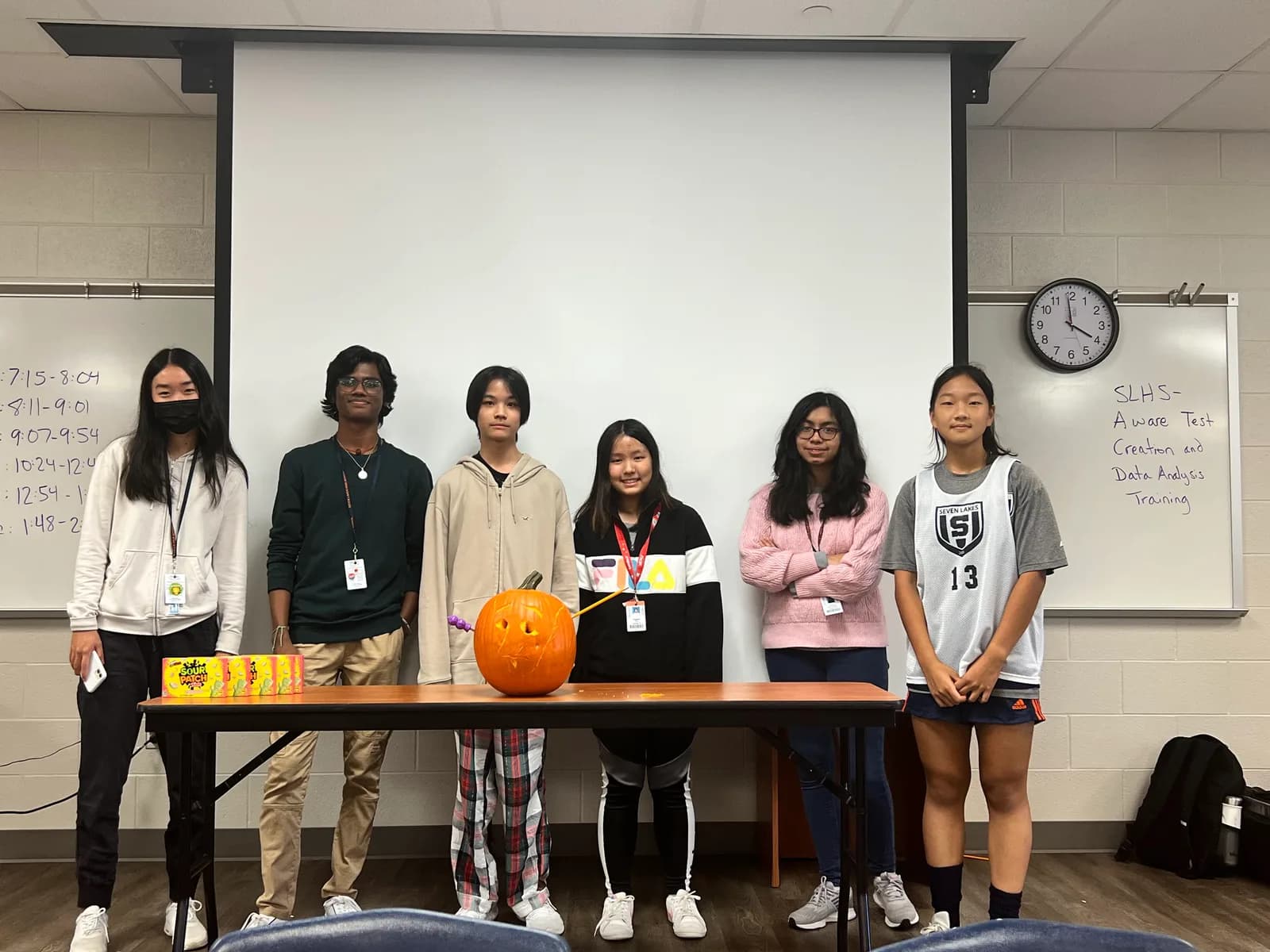 Members lined up behind their pumpkin and candy prizes