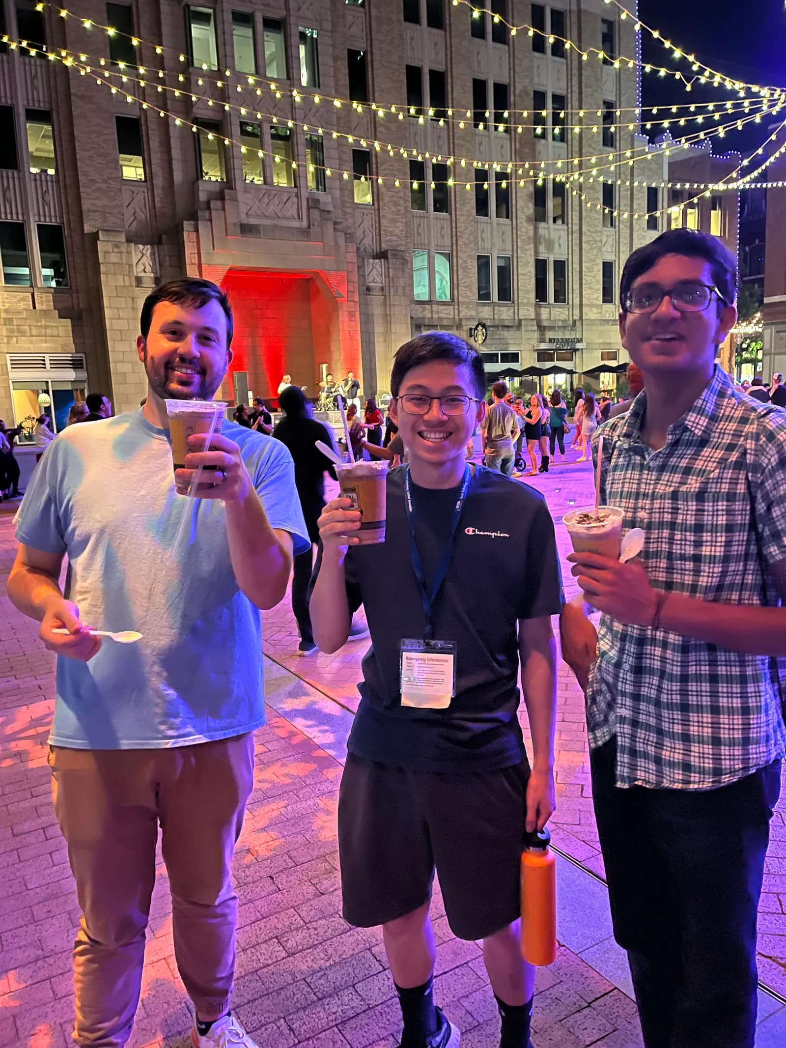 Members enjoying iced drinks downtown under string lights at State